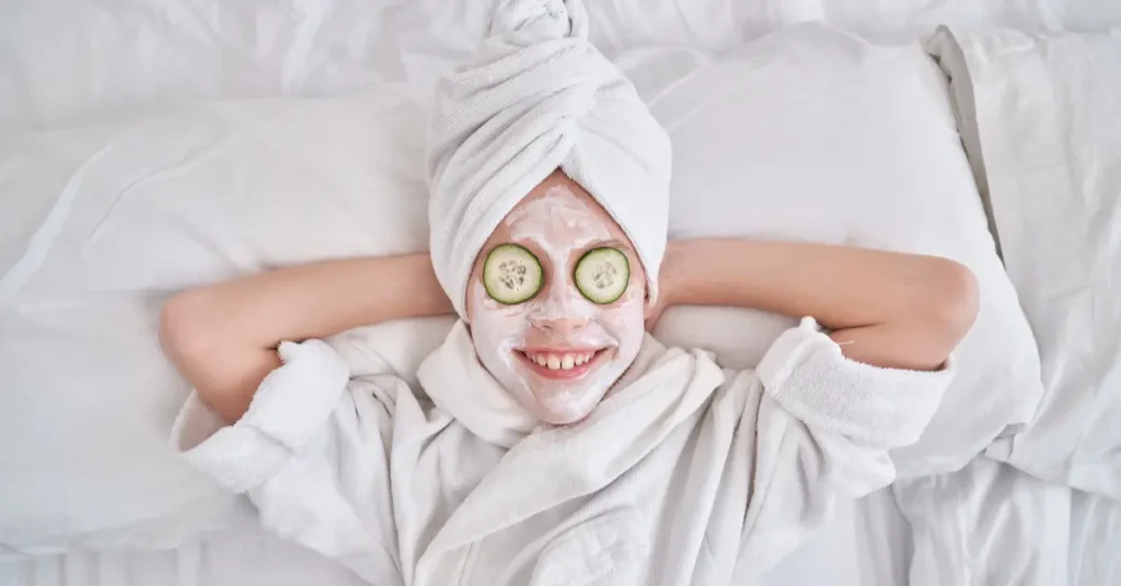 Παιδί χαμογελάει φορώντας μπουρνούζι κι έχοντας στο πρόσωπο κρέμα