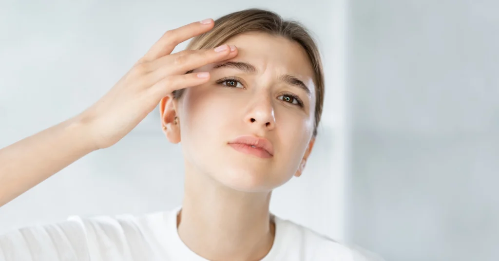 Κοπέλα ακουμπάει το μέτωπό της με τα δάχτυλά της