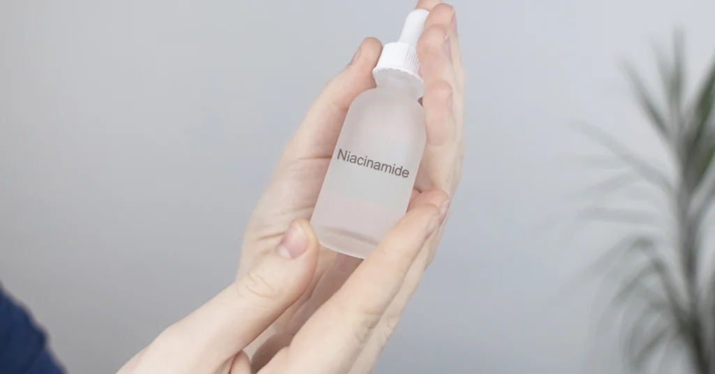 Κοπέλα κρατάει ένα γυάλινο μπουκαλάκι με υγρό νιασιναμίδης