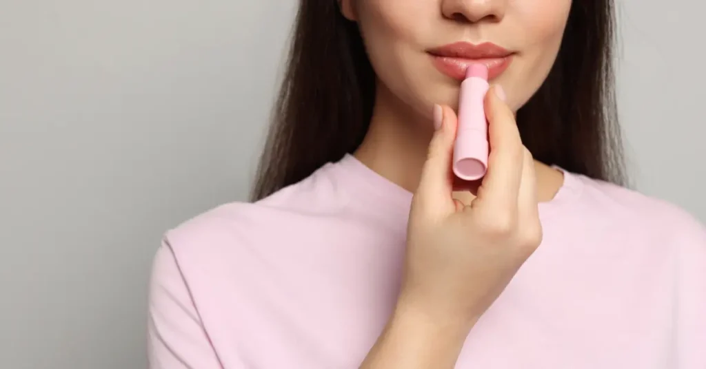 Κοπέλα ενυδατώνει τα χείλη της με lip balm